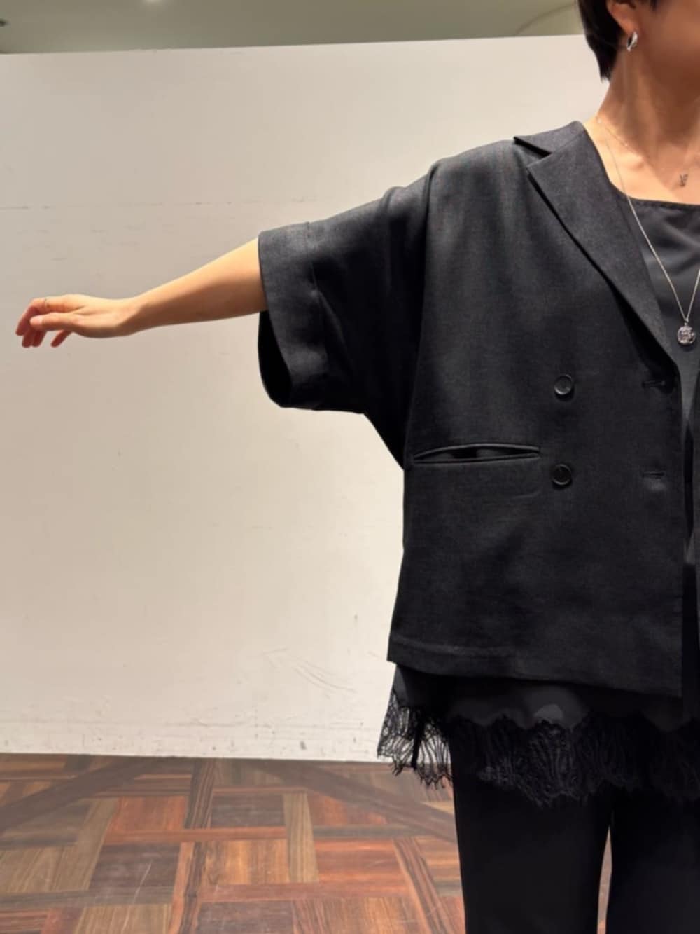 ホワイト系のトートバッグ、ブラック系のテーラードジャケット、ブラック系のその他パンツを着用したレディースの春コーディネートの6枚目の写真