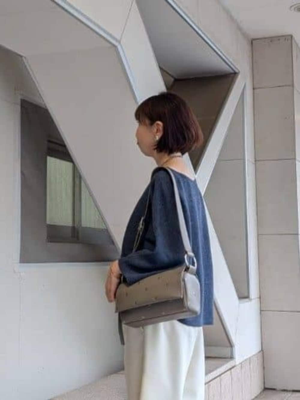 グレー系のショルダーバッグ、ホワイト系のその他パンツ、ブルー系のニット/セーターを着用したレディースの冬コーディネートの5枚目の写真