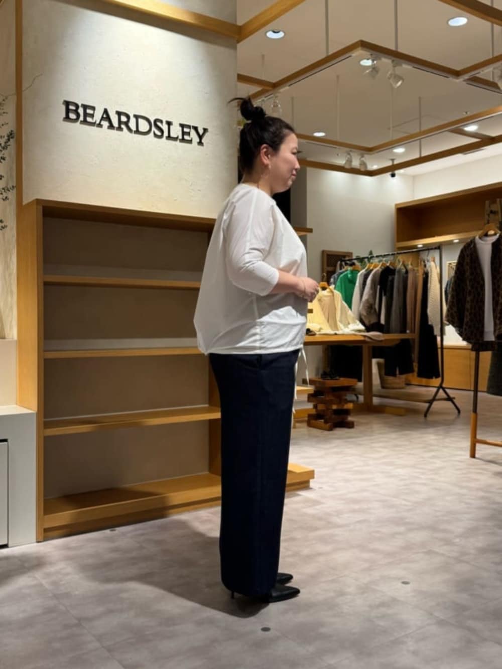 グレー系のボストンバッグ、ブラック系のブーツ、ホワイト系のシャツ/ブラウスを着用したレディースの冬コーディネートの5枚目の写真