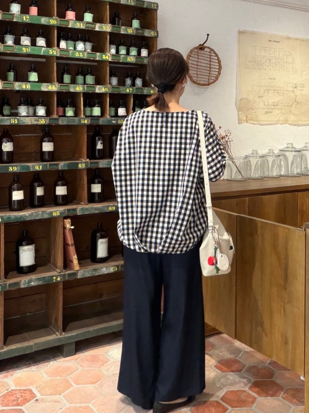 ブルー系のその他パンツ、ブラック系のシャツ/ブラウス、ホワイト系のトートバッグを着用したレディースの春コーディネートの5枚目の写真