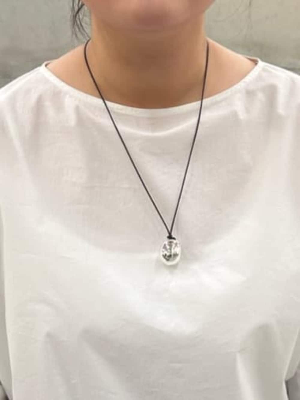 ブラック系のボストンバッグ、ホワイト系のシャツ/ブラウス、ブラック系のその他パンツを着用したレディースの冬コーディネートの7枚目の写真