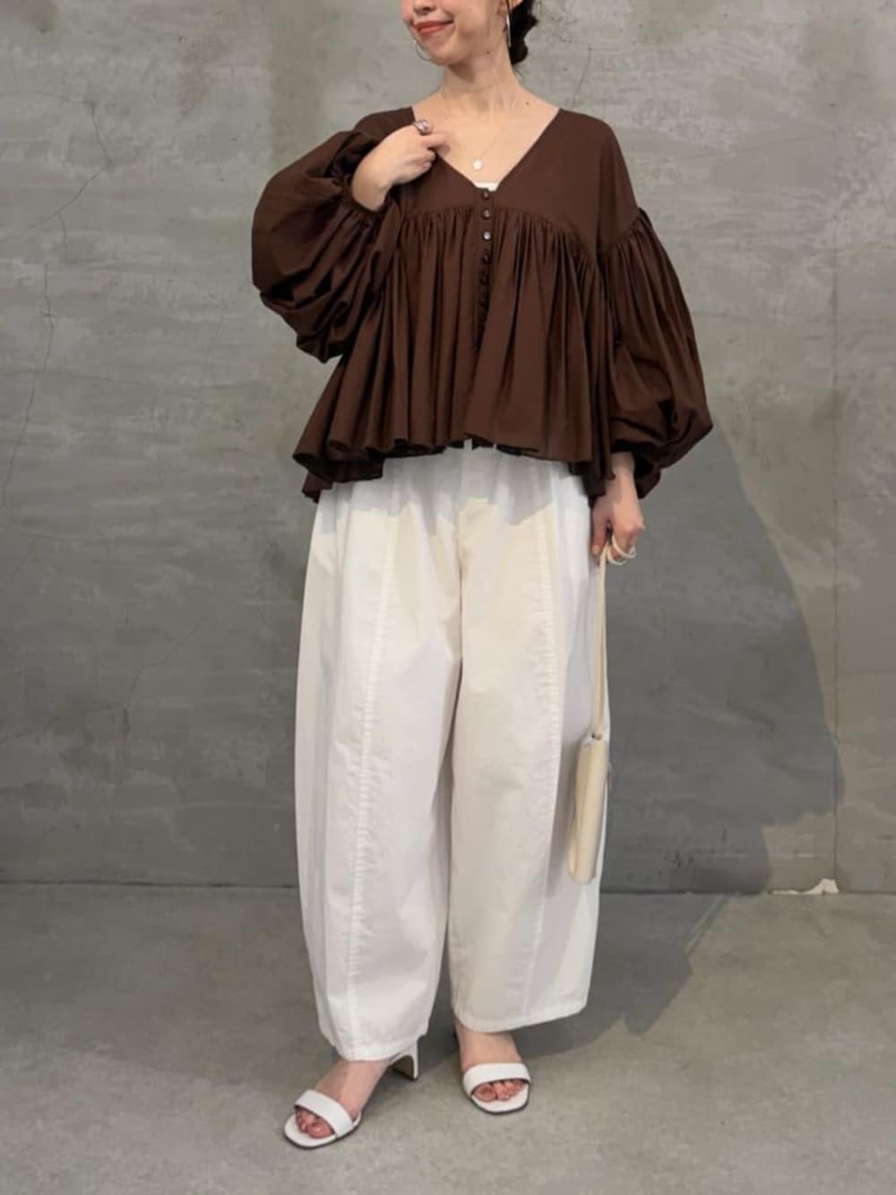 ホワイト系のショルダーバッグ、ホワイト系のその他パンツ、ブラウン系のシャツ/ブラウスを着用したレディースの冬コーディネートの5枚目の写真