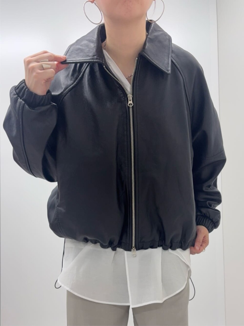 ブラック系のブルゾン、ホワイト系のシャツ/ブラウスを着用したレディースの冬コーディネートの4枚目の写真