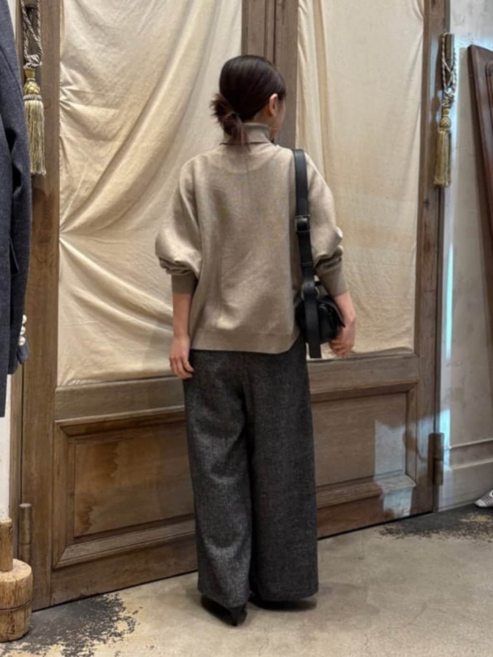 ブラック系のショルダーバッグ、ブラウン系のニット/セーター、グレー系のその他パンツを着用したレディースの秋コーディネートの7枚目の写真