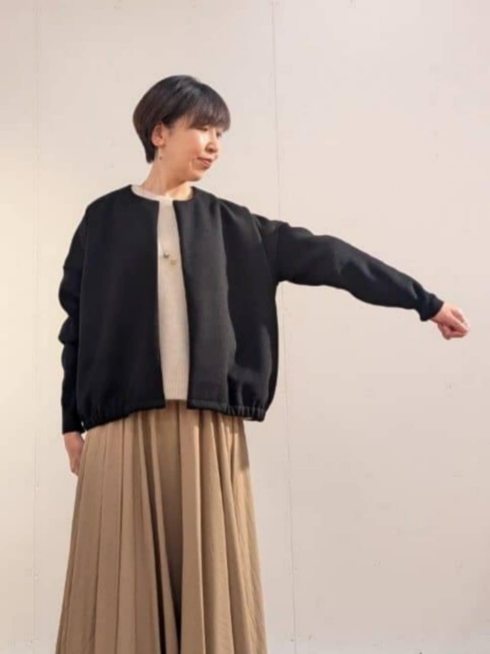 ブラウン系のスカート、ブラック系のブルゾンを着用したレディースの秋コーディネートの4枚目の写真