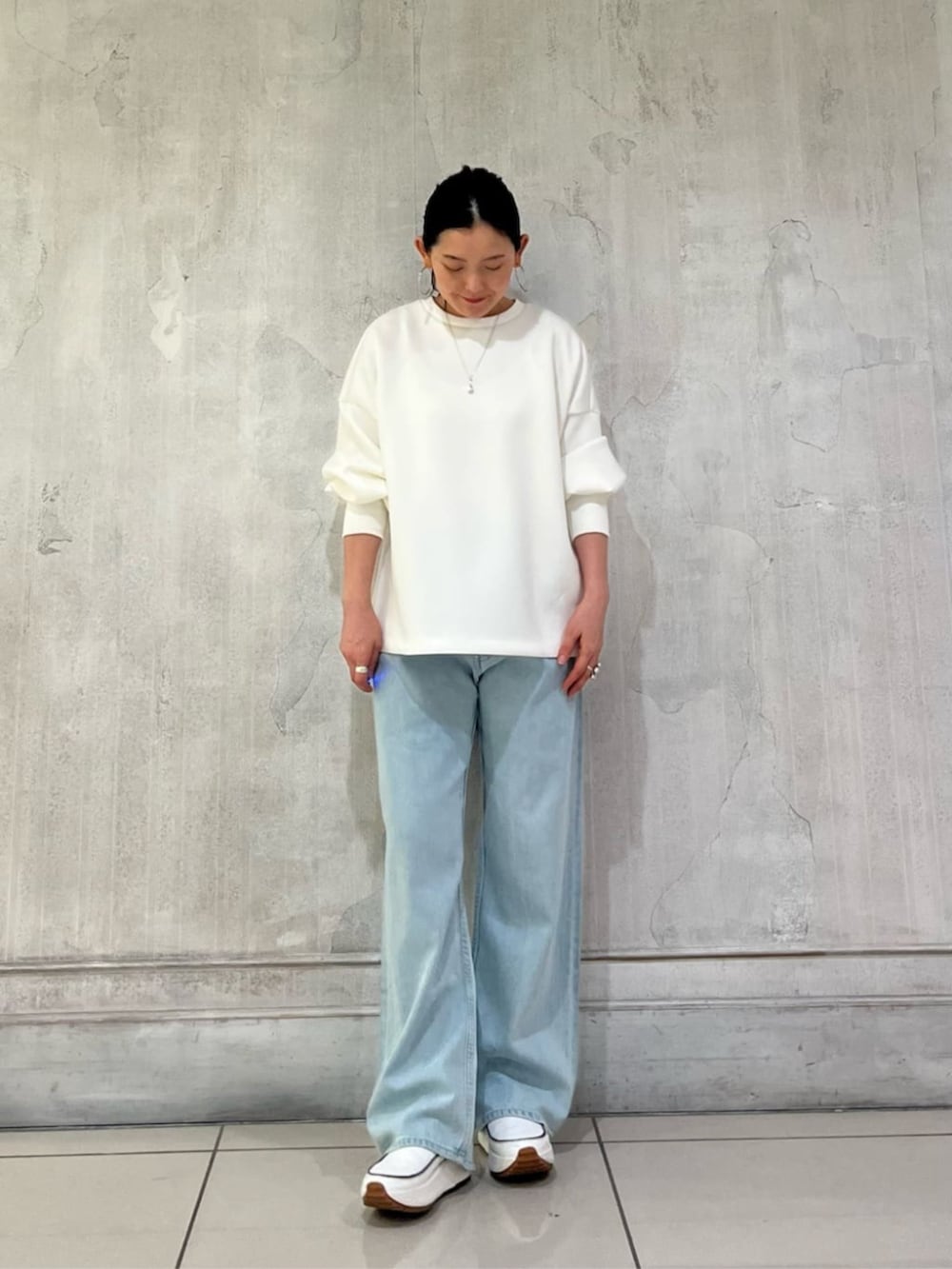 ブラック系のトートバッグ、ブラウン系のポーチを着用したレディースの冬コーディネートの6枚目の写真