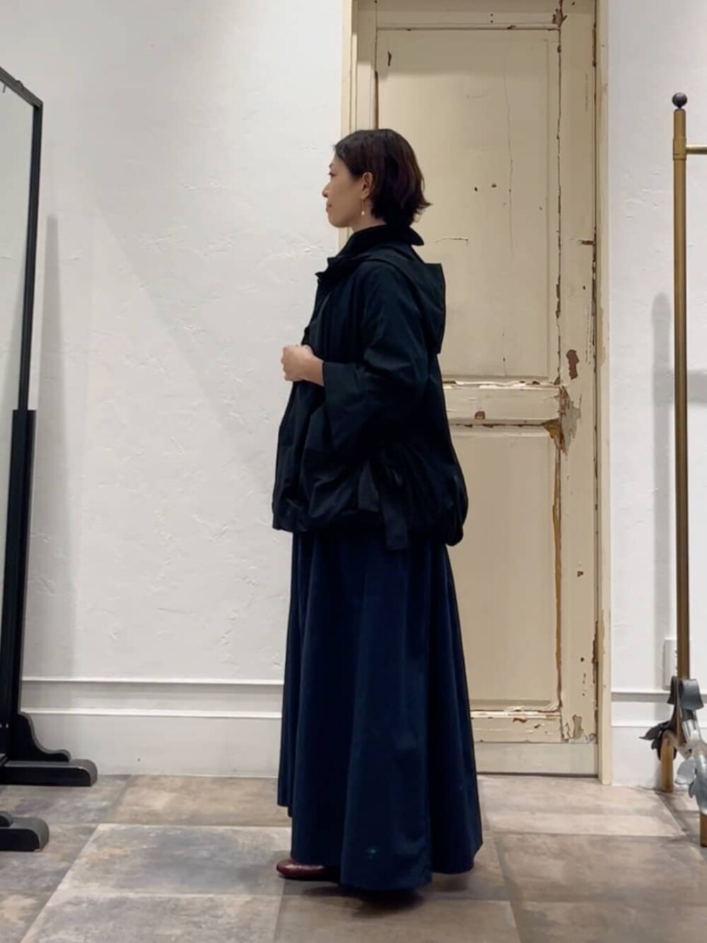 ブラック系のボストンバッグ、ブラック系のブルゾン、ブルー系のワンピースを着用したレディースの冬コーディネートの2枚目の写真