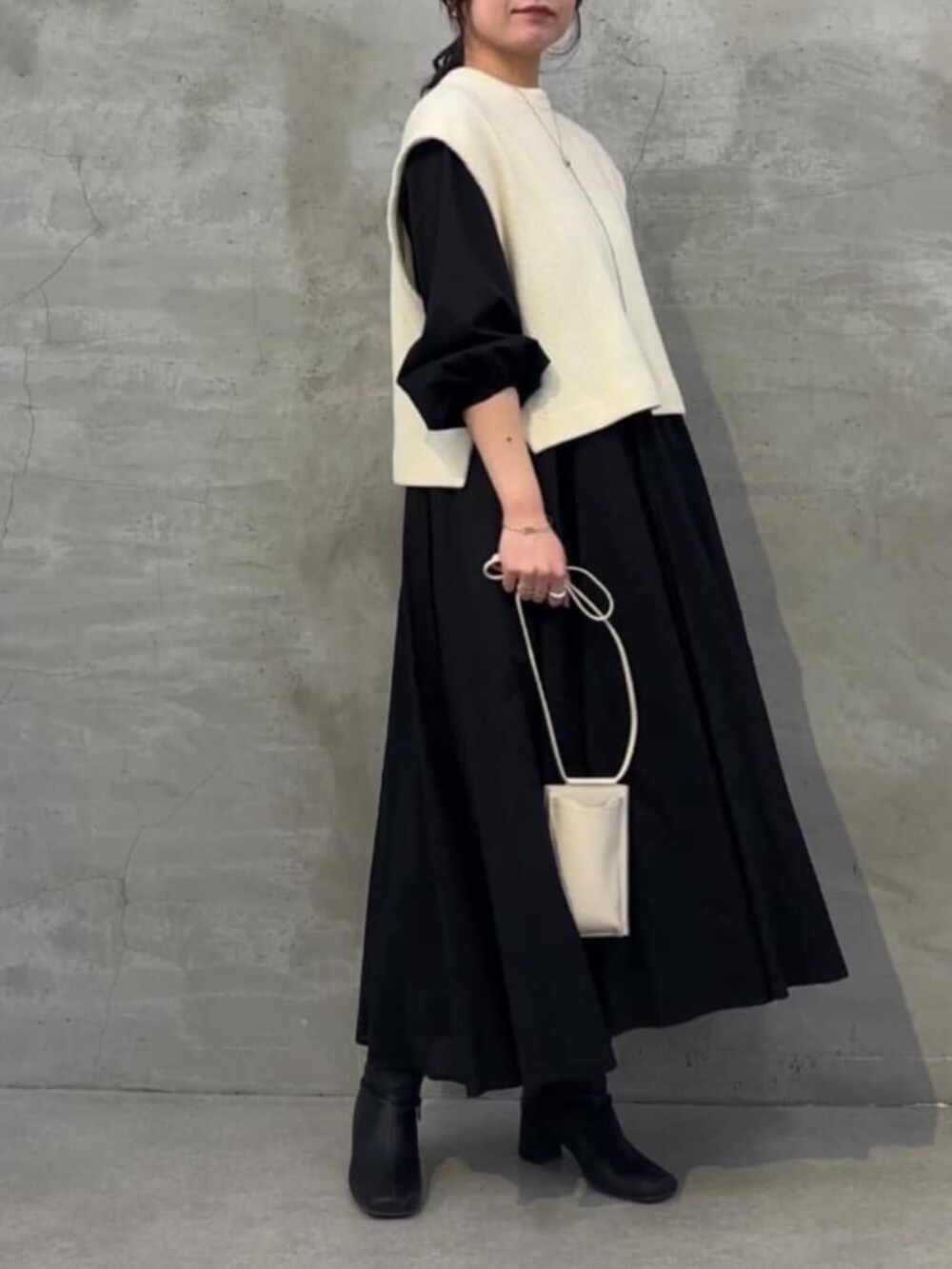 ブラック系のワンピース、ホワイト系のシャツ/ブラウス、ホワイト系のショルダーバッグを着用したレディースの冬コーディネートの6枚目の写真