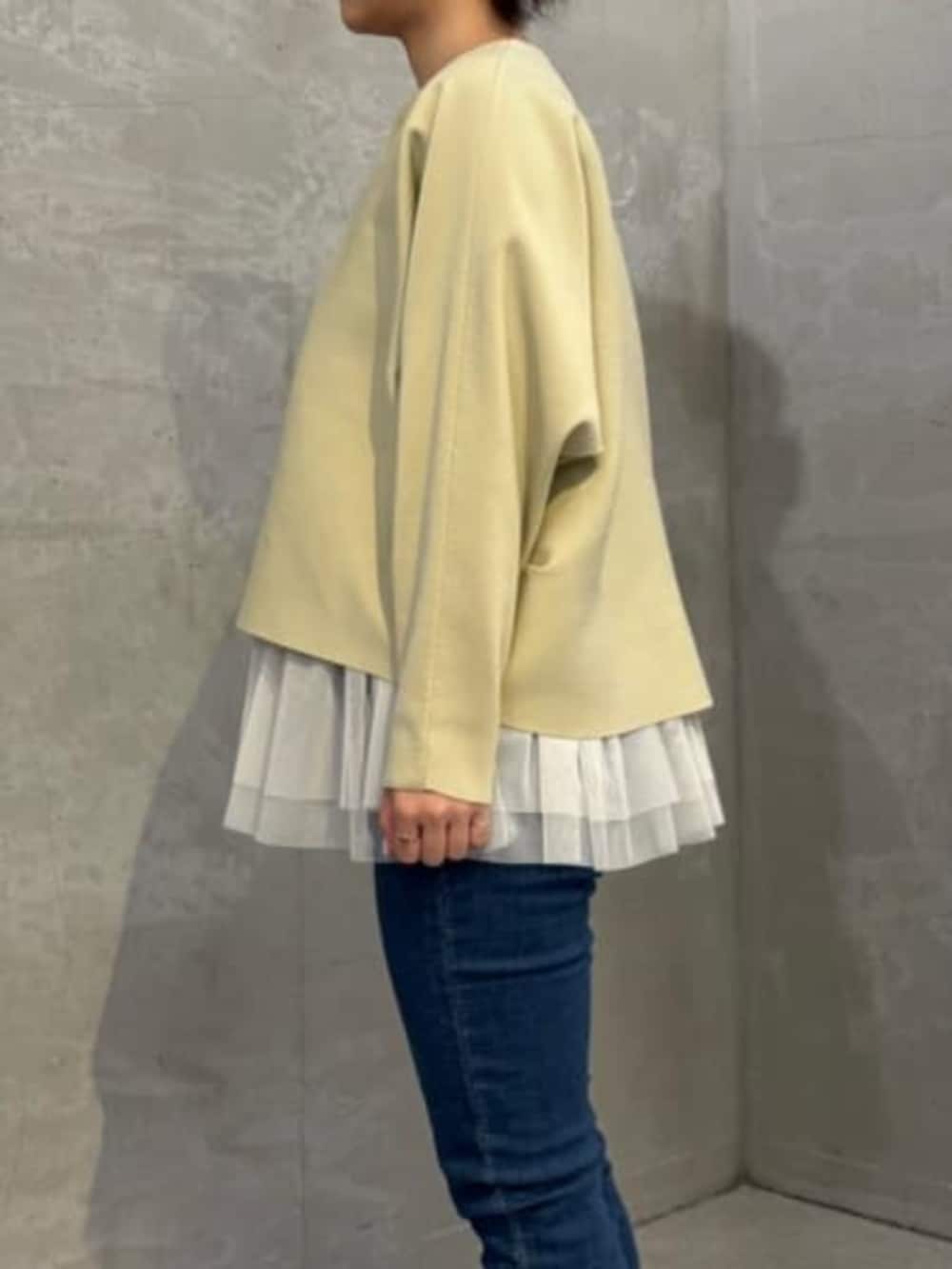 ホワイト系のキャミソール、ブルー系のデニムパンツ、ベージュ系のカーディガン/ボレロを着用したレディースの秋コーディネートの6枚目の写真