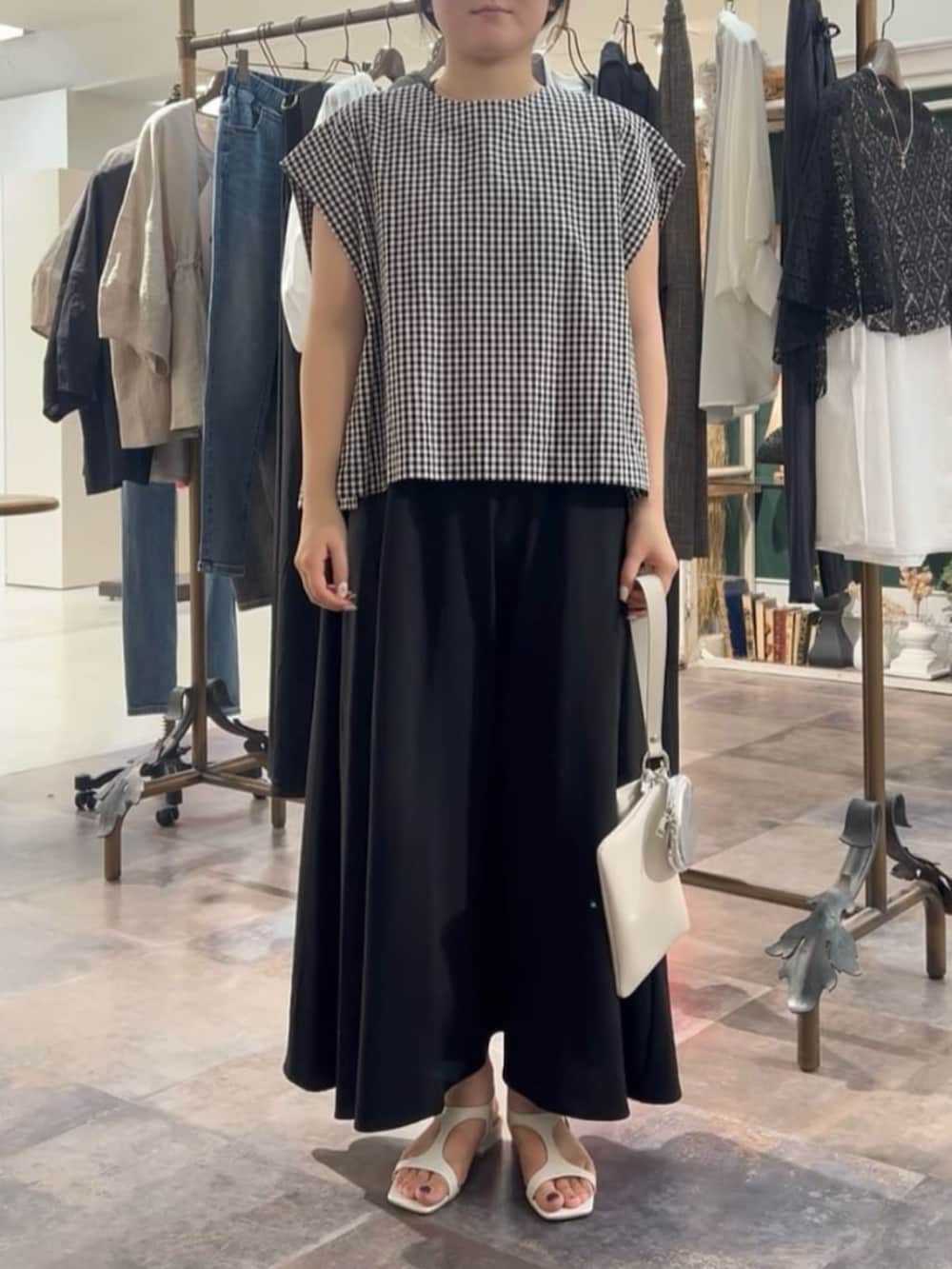 ブラック系のワンピースを着用したレディースの春コーディネートの2枚目の写真