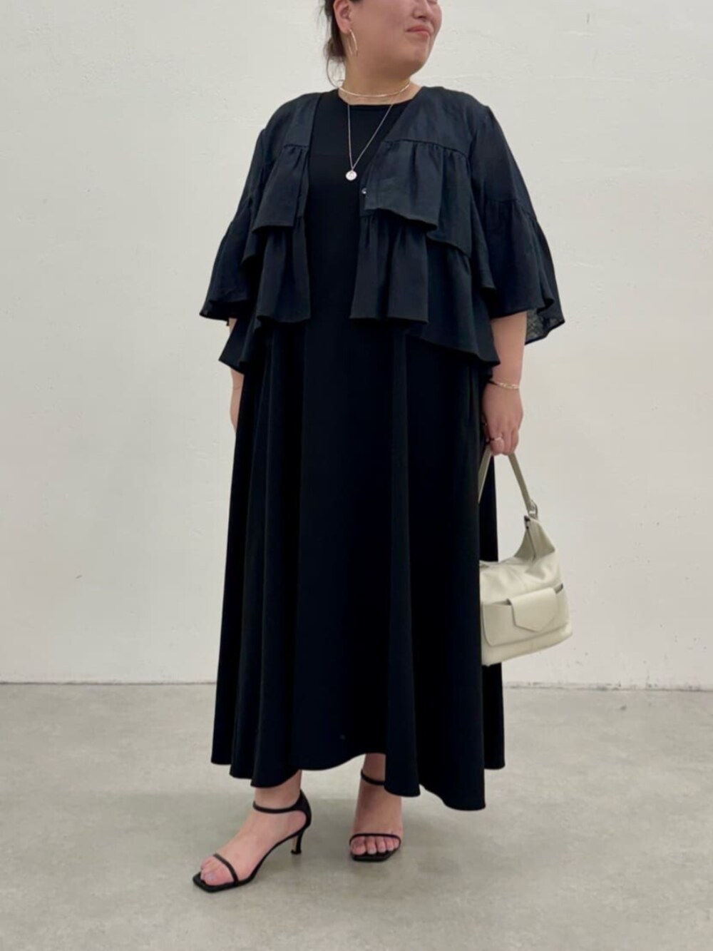 ブラック系のワンピース、ブラック系のその他アウターを着用したレディースの春コーディネートの5枚目の写真