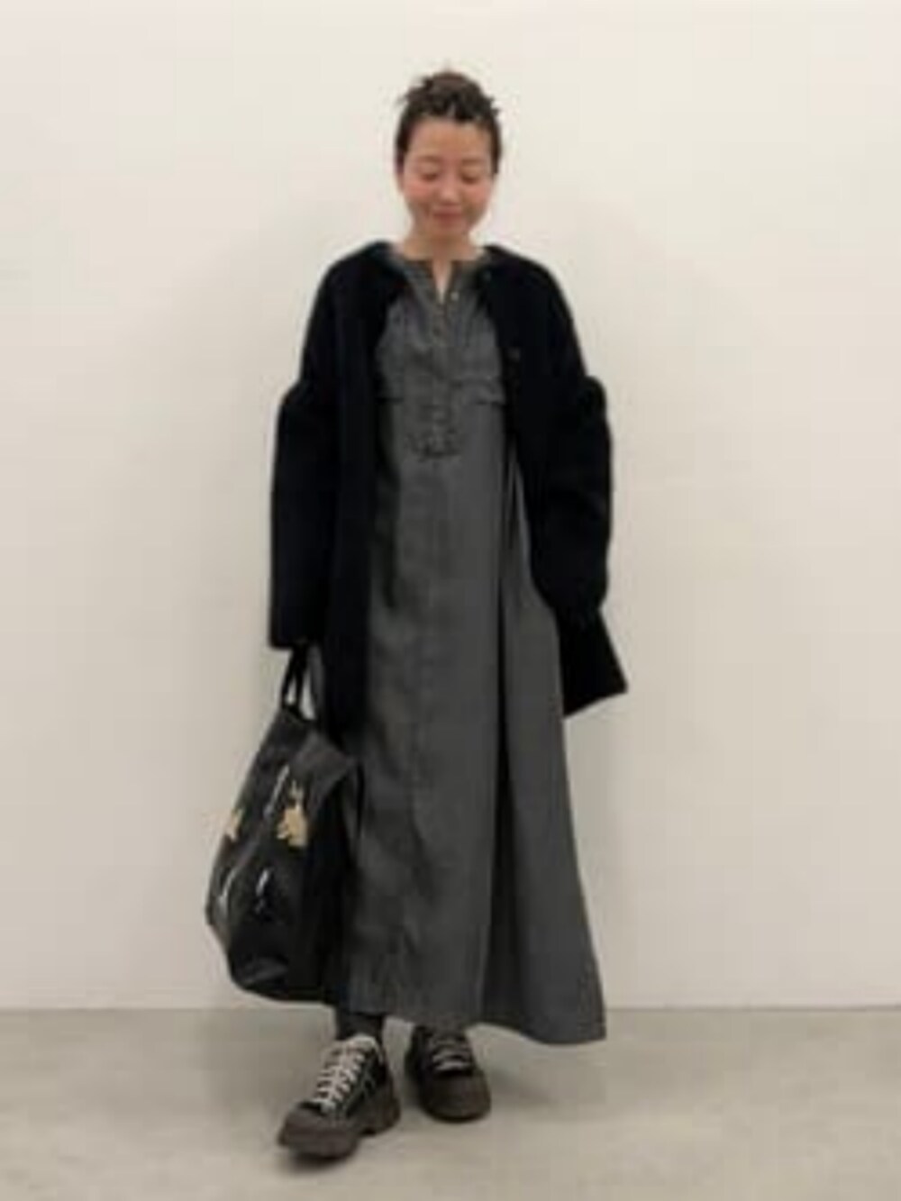 ブラック系のトートバッグを着用したレディースの秋コーディネートの2枚目の写真