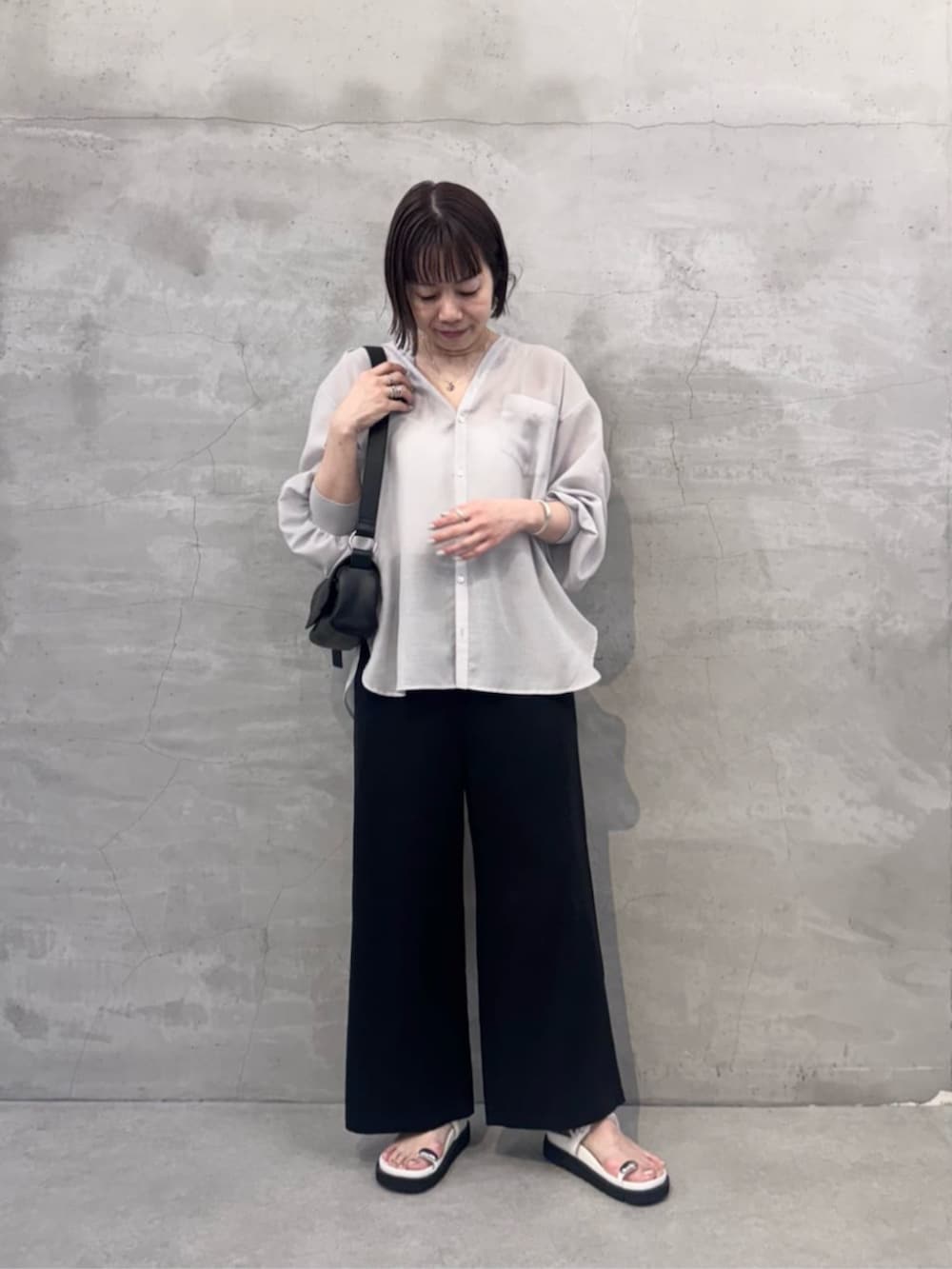 ブラック系のその他パンツ、ブラック系のショルダーバッグ、ホワイト系のサンダルを着用したレディースの冬コーディネートの2枚目の写真