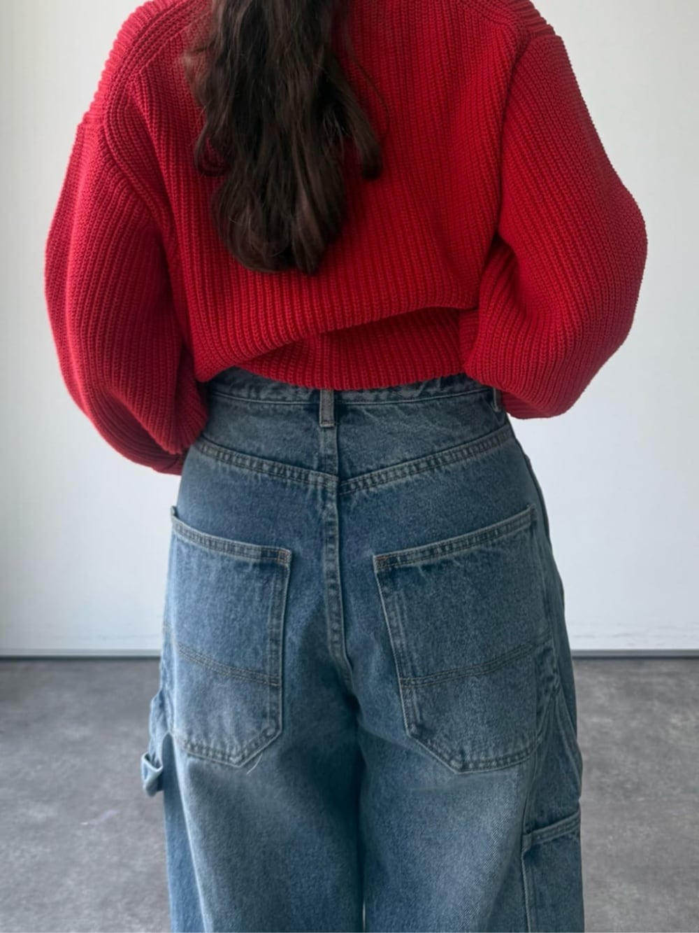 レッド系のニット/セーター、グレー系のトートバッグを着用したレディースの冬コーディネートの9枚目の写真