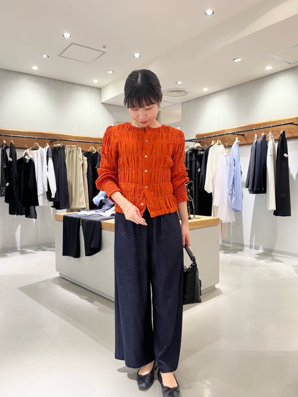 ブルー系のその他パンツ、オレンジ系のシャツ/ブラウスを着用したレディースの春コーディネートの3枚目の写真