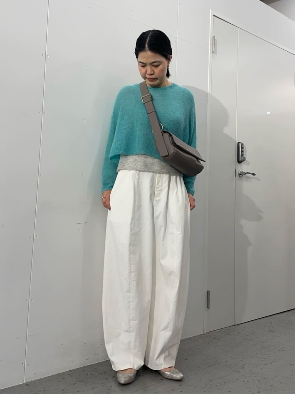 グレー系のショルダーバッグ、ブルー系のニット/セーター、ホワイト系のその他パンツを着用したレディースの夏コーディネートの6枚目の写真