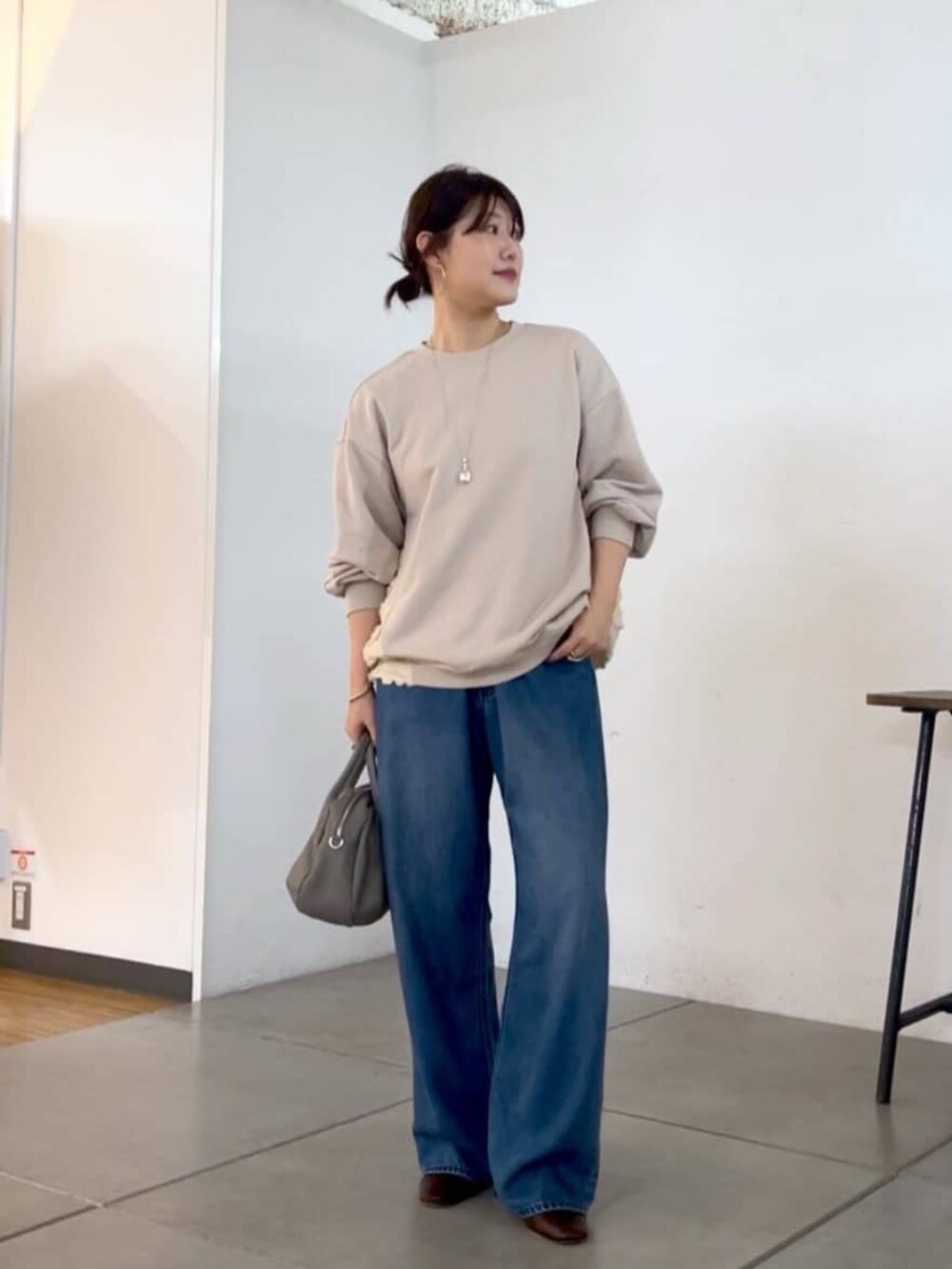 グレー系のトートバッグ、ホワイト系のTシャツ/カットソーを着用したレディースの秋コーディネートの5枚目の写真