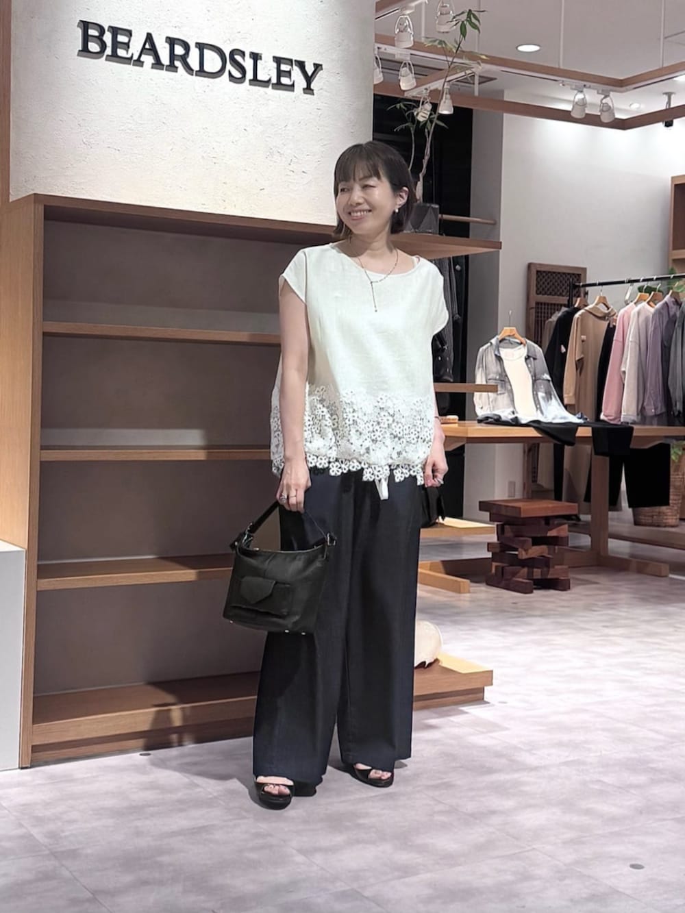 ブルー系のその他パンツ、ブラック系のトートバッグ、ホワイト系のシャツ/ブラウスを着用したレディースの春コーディネートの5枚目の写真