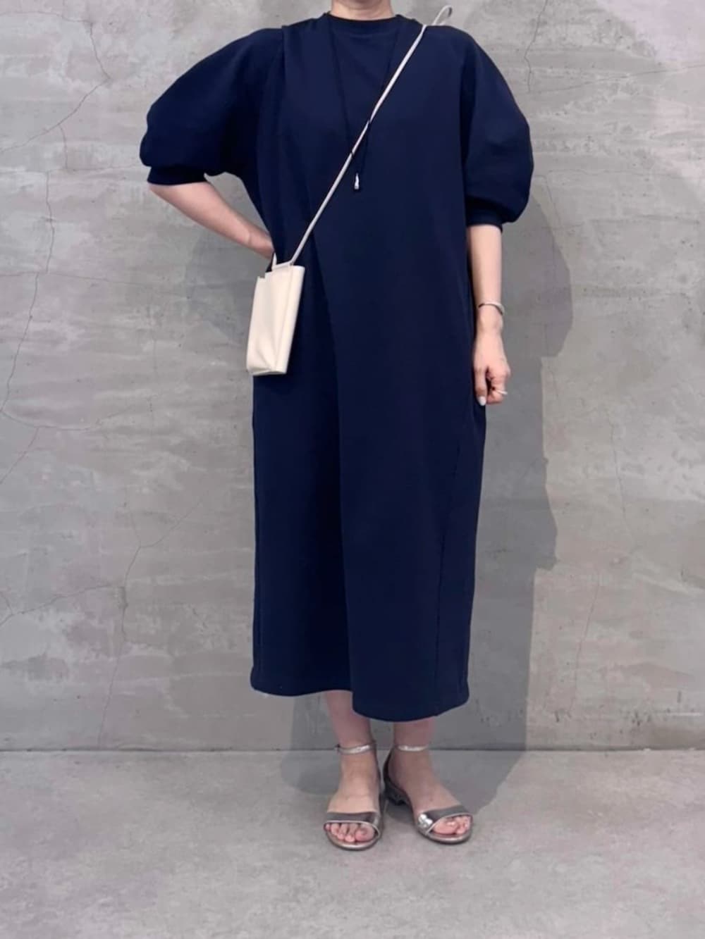 ホワイト系のショルダーバッグ、ブルー系のワンピースを着用したレディースの冬コーディネートの6枚目の写真