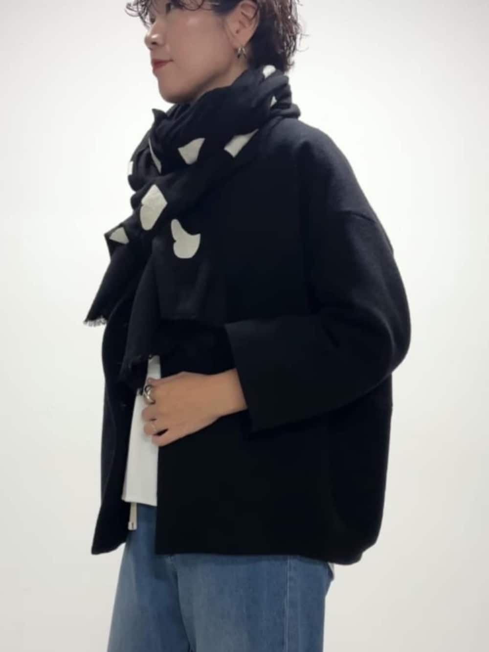 ブルー系のデニムパンツ、ブルー系のノーカラーコート、ホワイト系のシャツ/ブラウスを着用したレディースの冬コーディネートの3枚目の写真