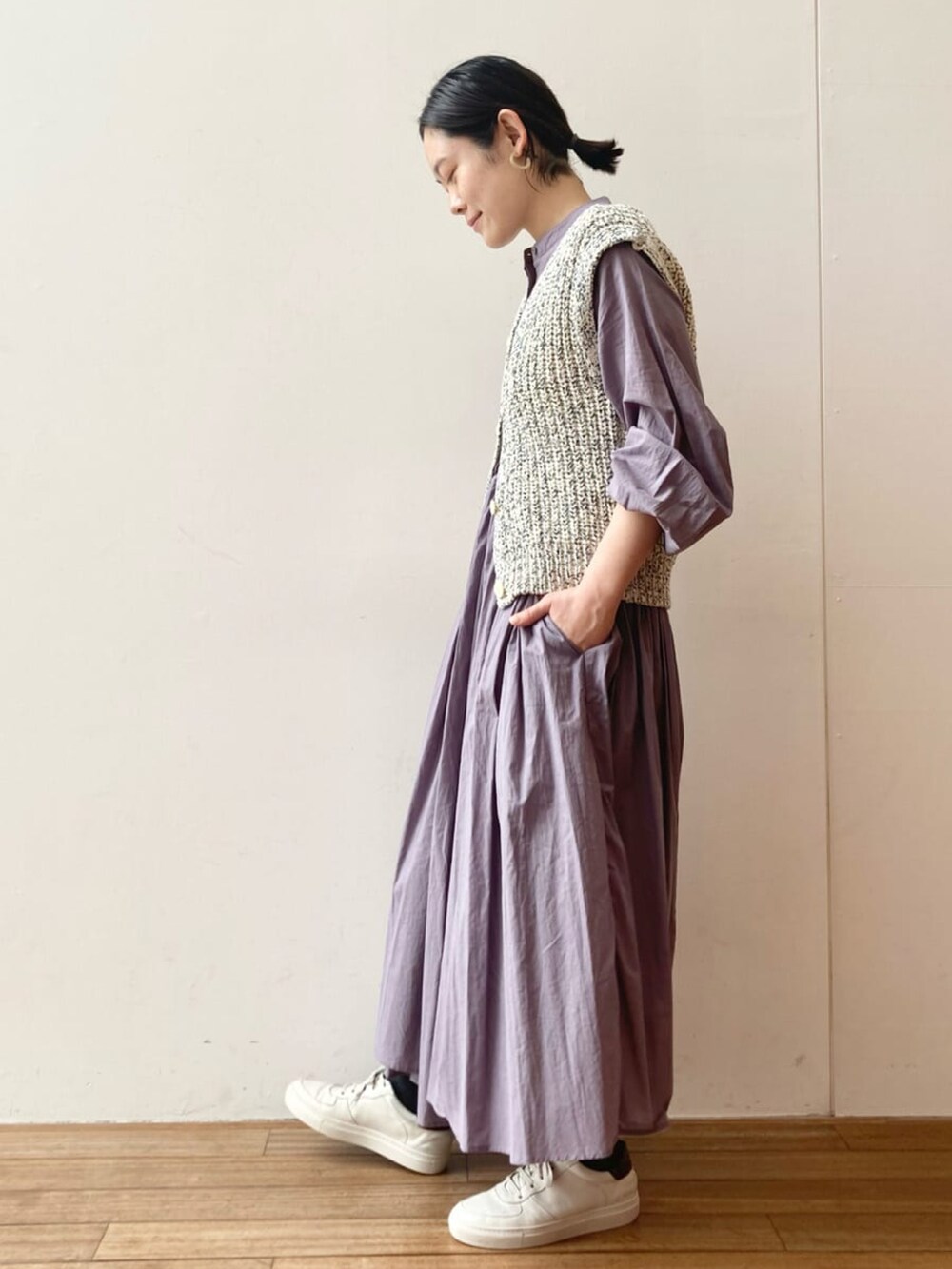 パープル系のワンピース、ブルー系のベストを着用したレディースの冬コーディネートの2枚目の写真