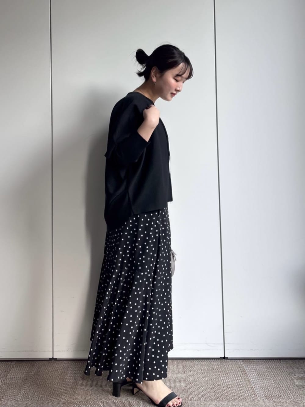 ブラック系のカーディガン/ボレロ、グレー系のボストンバッグ、ブラック系のスカートを着用したレディースの冬コーディネートの2枚目の写真