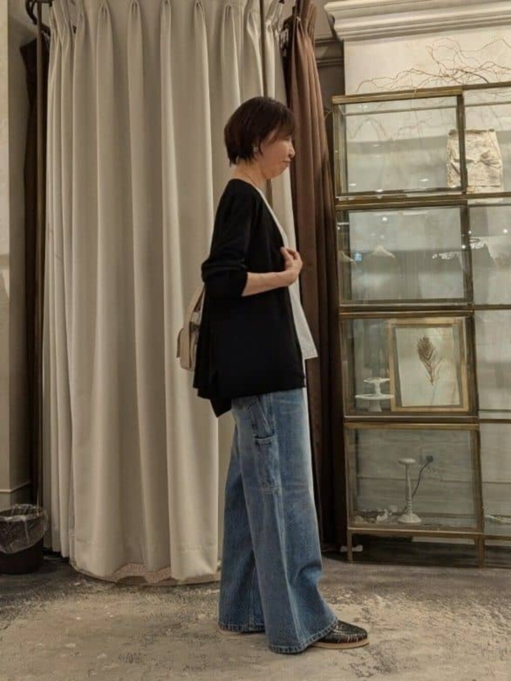 ホワイト系のタンクトップ、ベージュ系のショルダーバッグ、ブルー系のその他パンツを着用したレディースの春コーディネートの4枚目の写真
