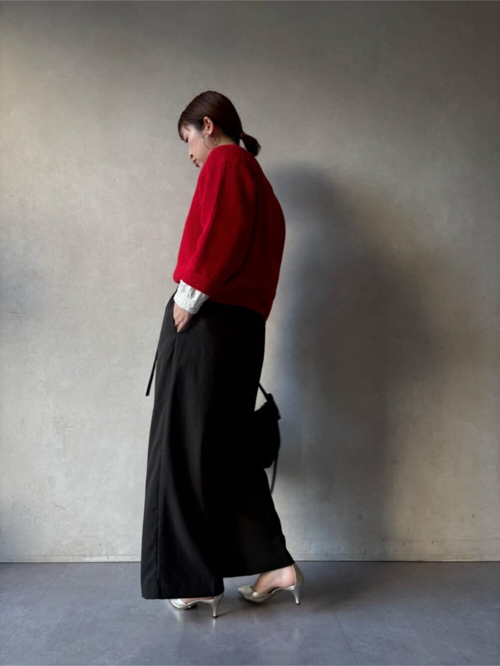 ブラック系のトートバッグ、グレー系のその他パンツ、レッド系のニット/セーターを着用したレディースの冬コーディネートの4枚目の写真