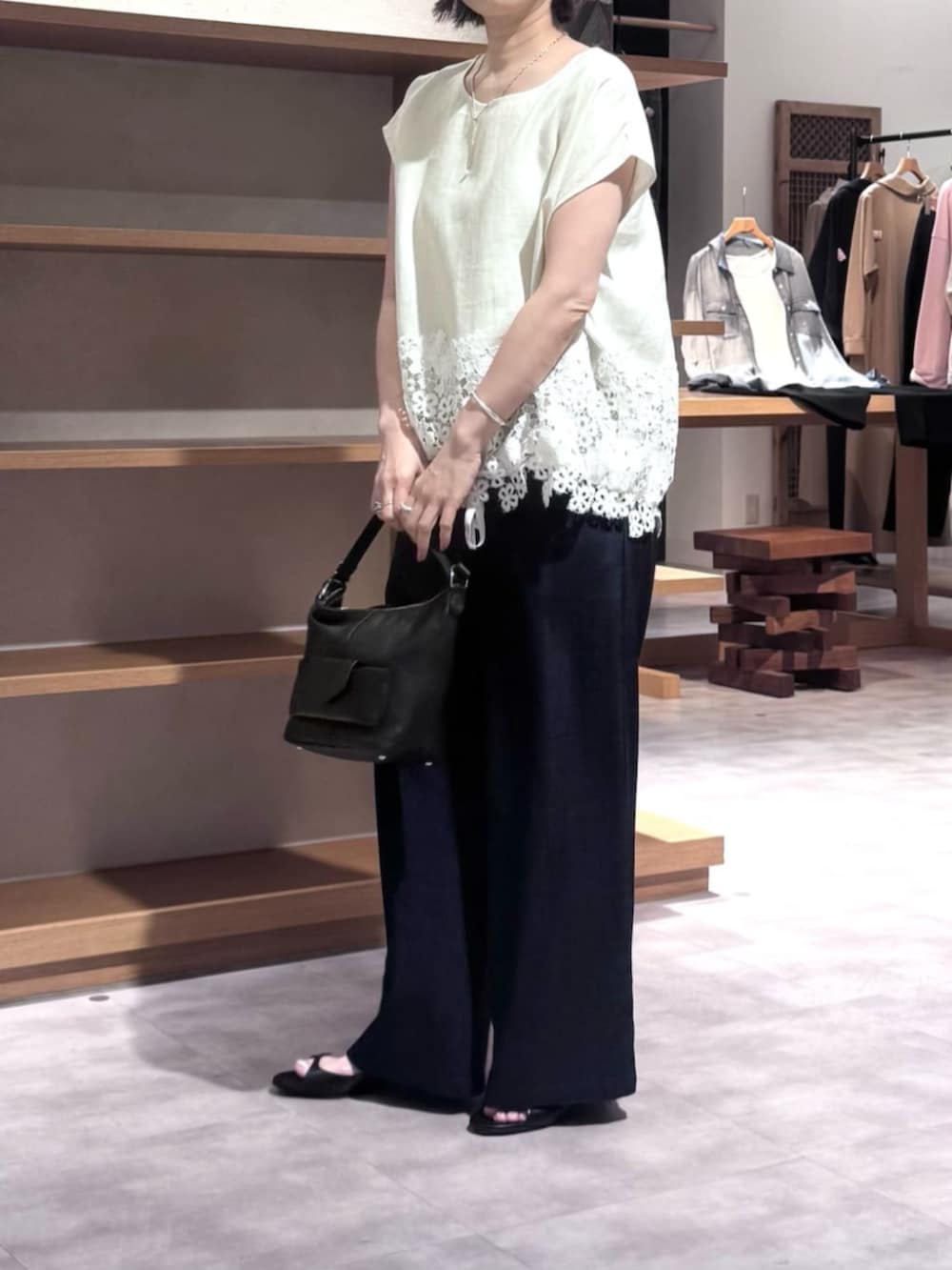 ブルー系のその他パンツ、ブラック系のトートバッグ、ホワイト系のシャツ/ブラウスを着用したレディースの春コーディネートの7枚目の写真