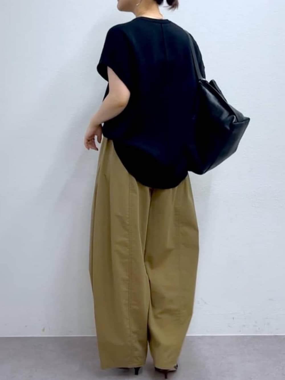 イエロー系のその他パンツ、ブラック系のニット/セーターを着用したレディースの夏コーディネートの4枚目の写真