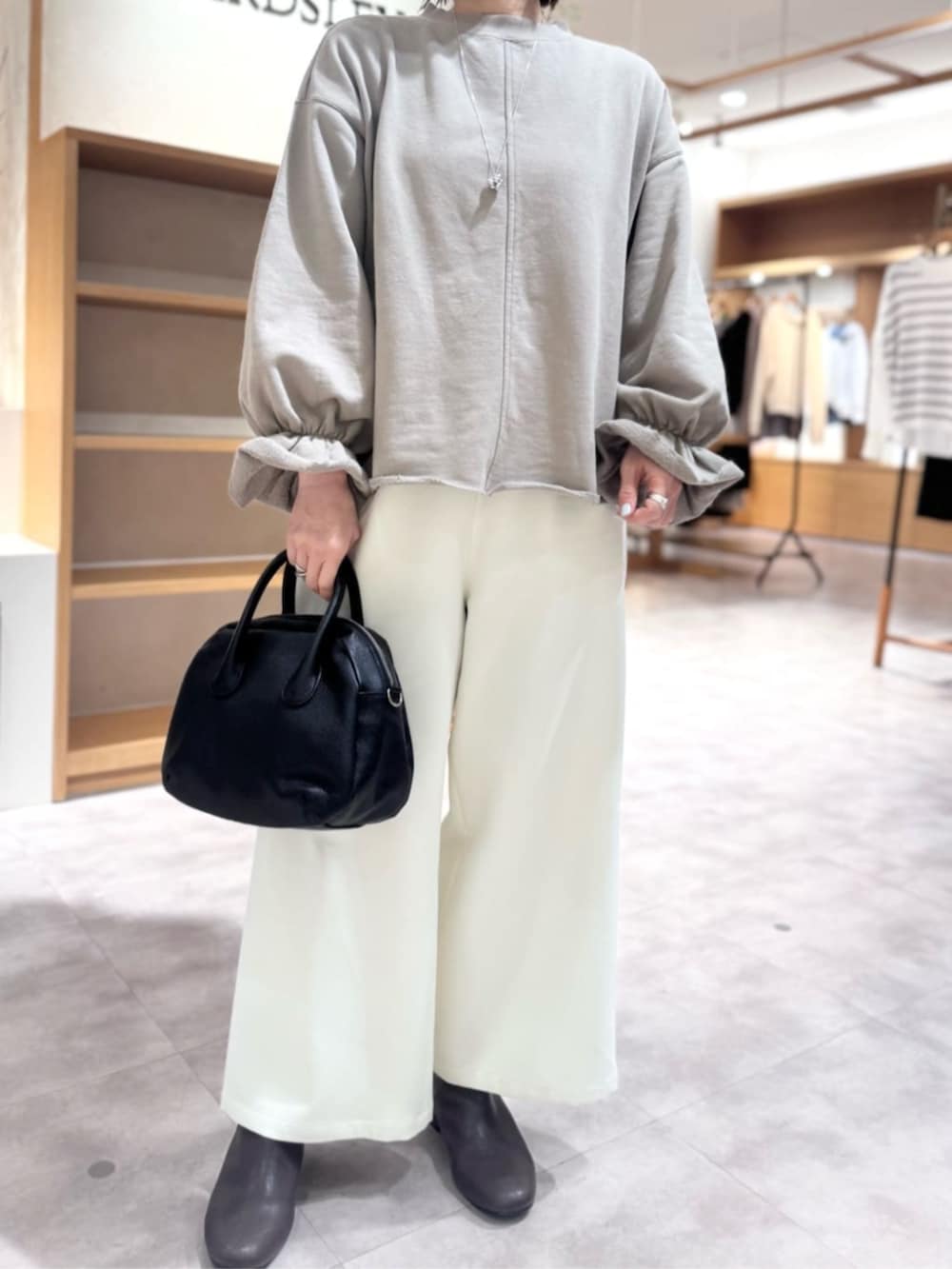 ブラック系のボストンバッグ、ブラウン系のTシャツ/カットソー、ホワイト系のその他パンツを着用したレディースの冬コーディネートの7枚目の写真