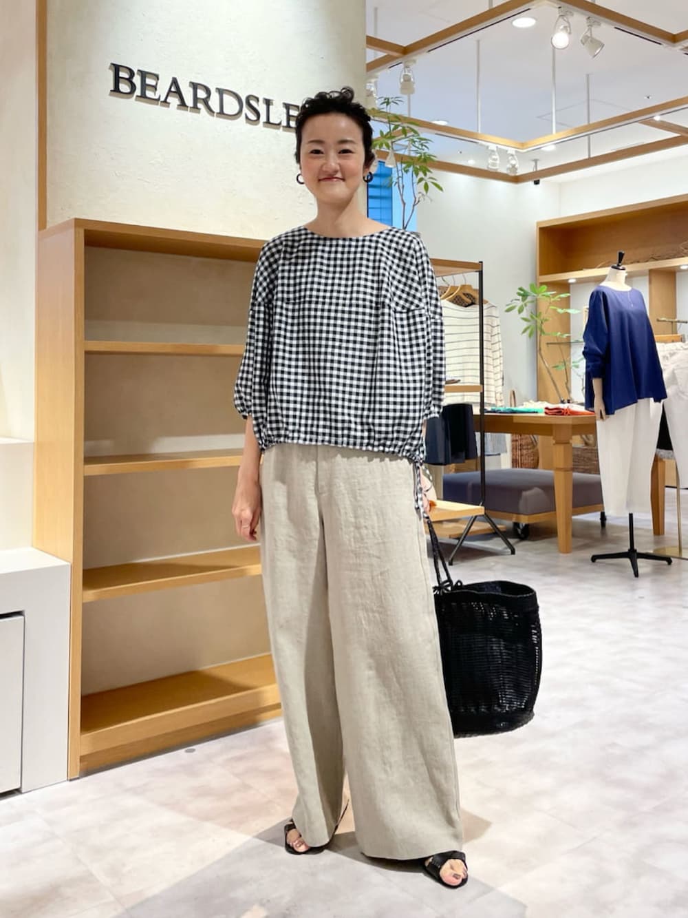 ホワイト系のシャツ/ブラウス、ベージュ系のその他パンツ、ブラック系のサンダルを着用したレディースの夏コーディネートの2枚目の写真