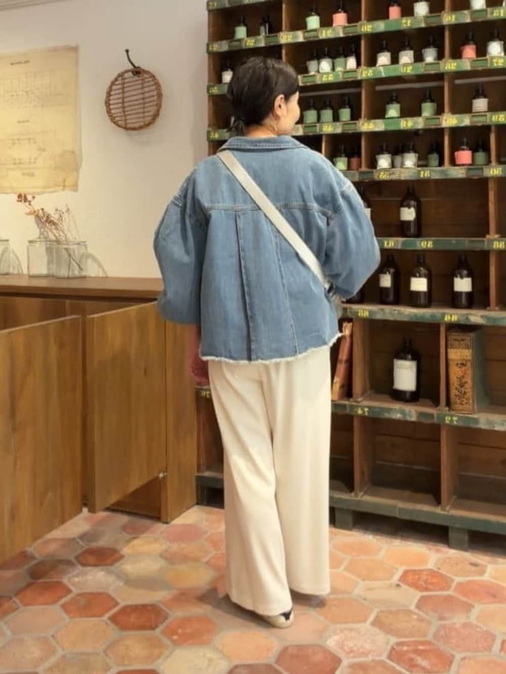 ブルー系のデニムジャケット、シルバー系のショルダーバッグ、ブルー系のTシャツ/カットソーを着用したレディースの冬コーディネートの3枚目の写真