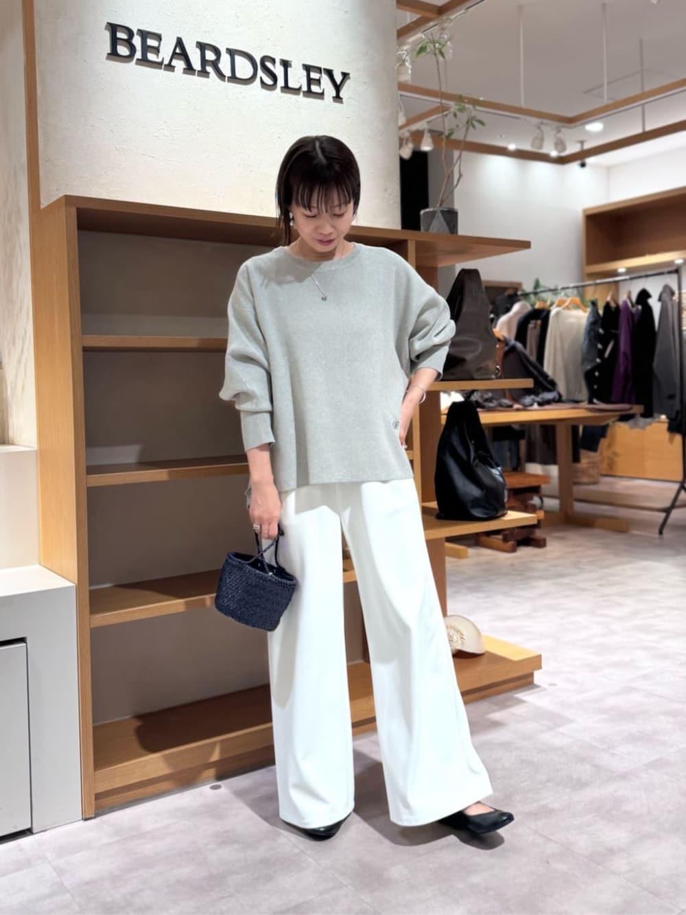 ホワイト系のその他パンツ、ブルー系のハンドバッグ、グレー系のニット/セーターを着用したレディースの冬コーディネートの3枚目の写真