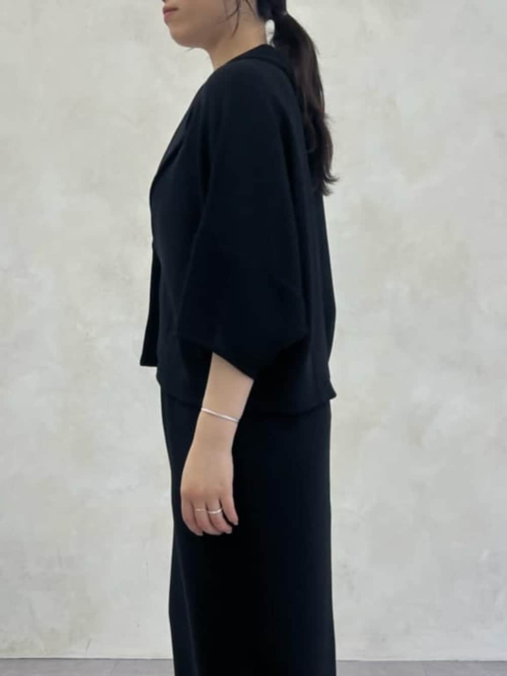 グレー系のハンドバッグ、ブラック系のテーラードジャケット、ブラック系のスカートを着用したレディースの春コーディネートの7枚目の写真