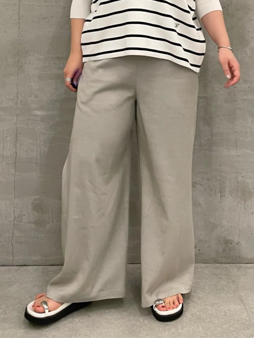 ブラック系のショルダーバッグ、ホワイト系のニット/セーター、ホワイト系のサンダルを着用したレディースの冬コーディネートの7枚目の写真