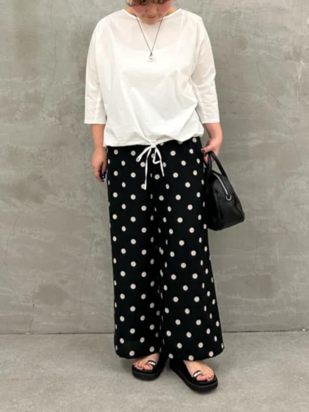 ブラック系のボストンバッグ、ホワイト系のシャツ/ブラウス、ブラック系のその他パンツを着用したレディースの冬コーディネートの3枚目の写真