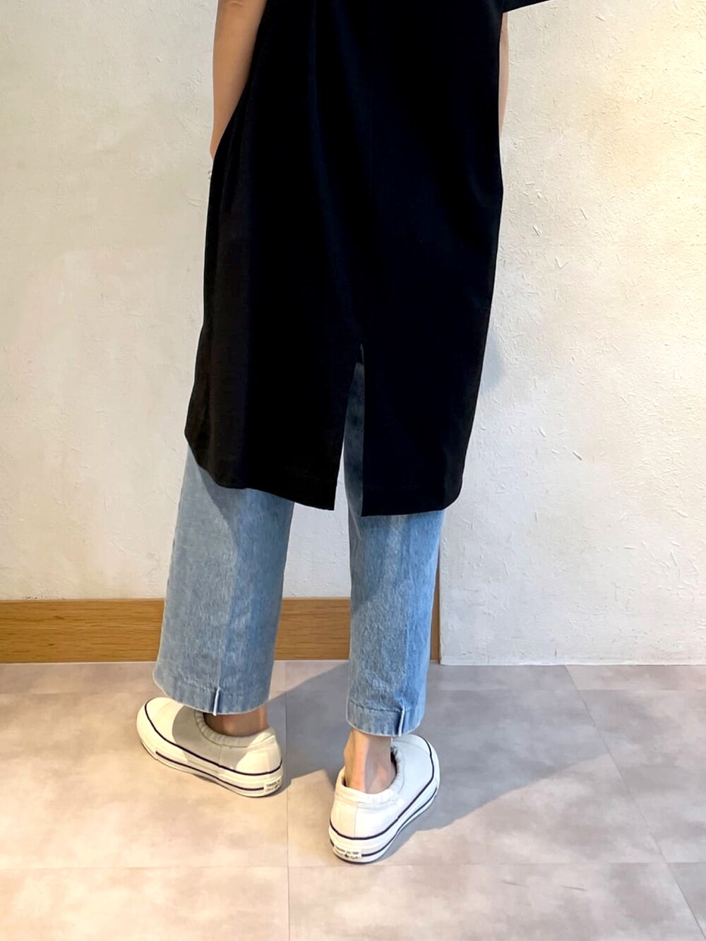 ブラック系のTシャツ/カットソー、ベージュ系のショルダーバッグ、ホワイト系のスニーカーを着用したレディースの春コーディネートの3枚目の写真