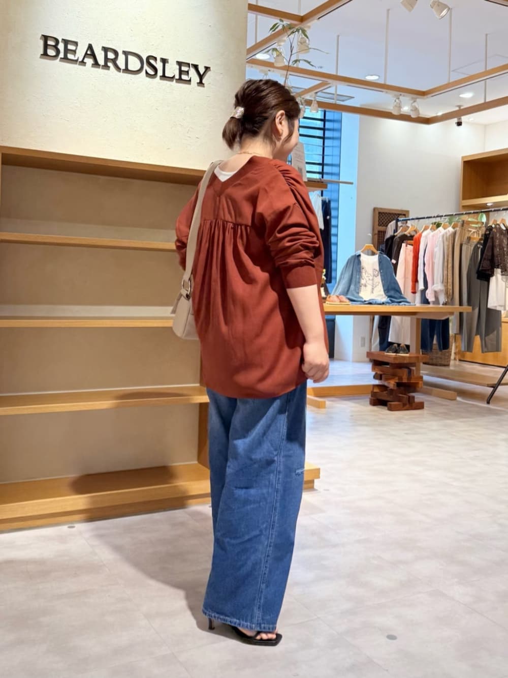 ベージュ系のショルダーバッグ、ブルー系のその他パンツ、レッド系のシャツ/ブラウスを着用したレディースの春コーディネートの4枚目の写真