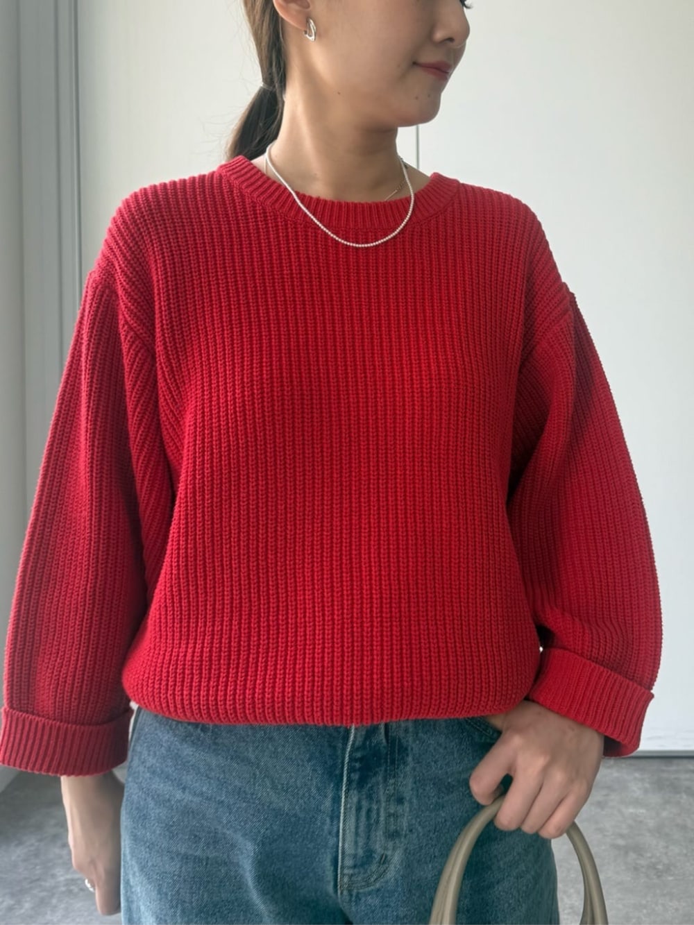 レッド系のニット/セーター、グレー系のトートバッグを着用したレディースの冬コーディネートの5枚目の写真