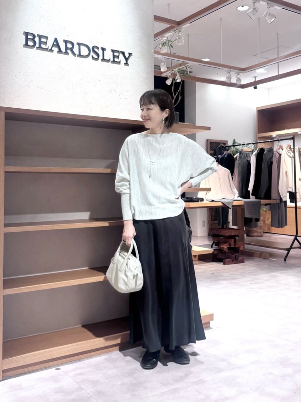 ブラック系のスカート、グレー系のボストンバッグ、グレー系のニット/セーターを着用したレディースの冬コーディネートの2枚目の写真