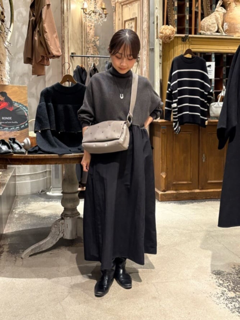 グレー系のワンピース、グレー系のショルダーバッグを着用したレディースの冬コーディネートの6枚目の写真