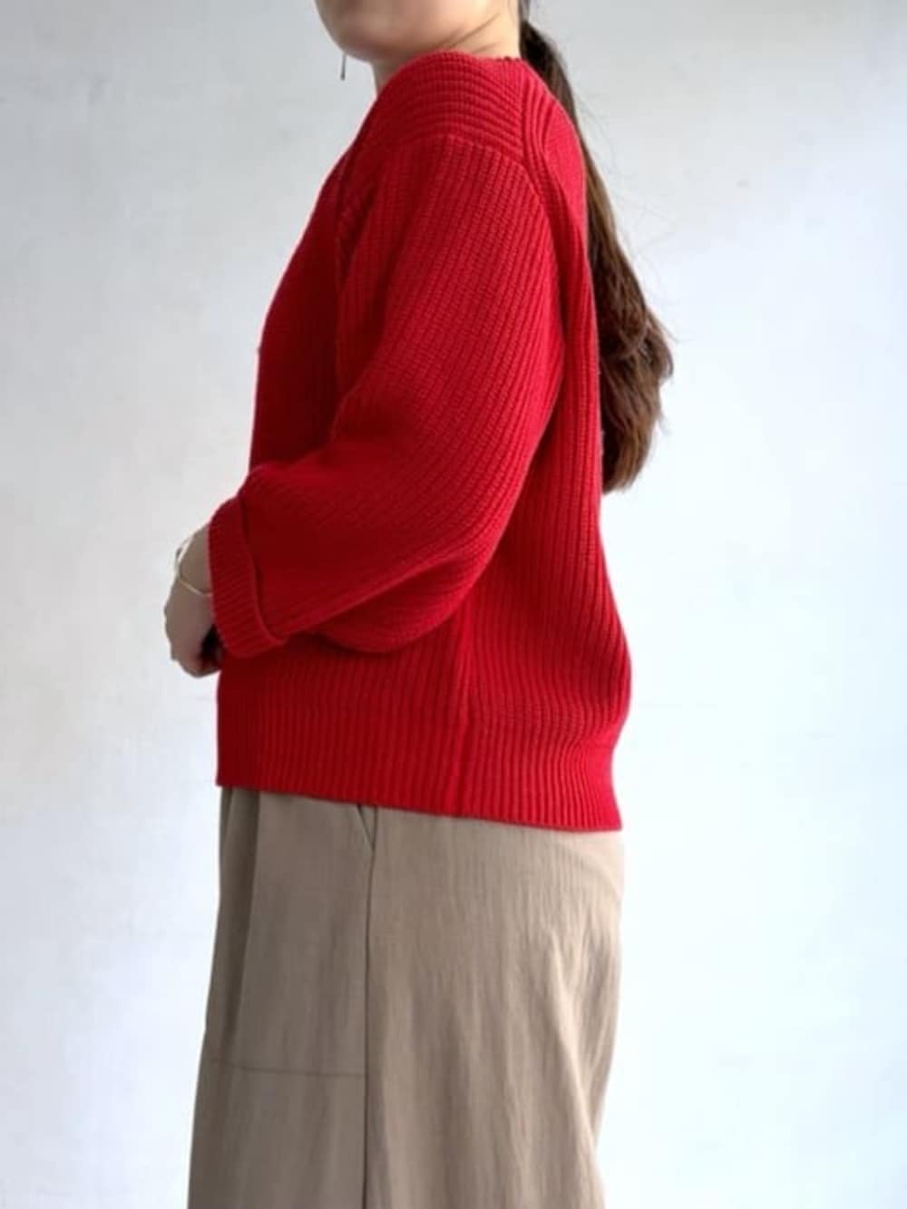 ベージュ系のその他パンツ、レッド系のニット/セーターを着用したレディースの冬コーディネートの8枚目の写真