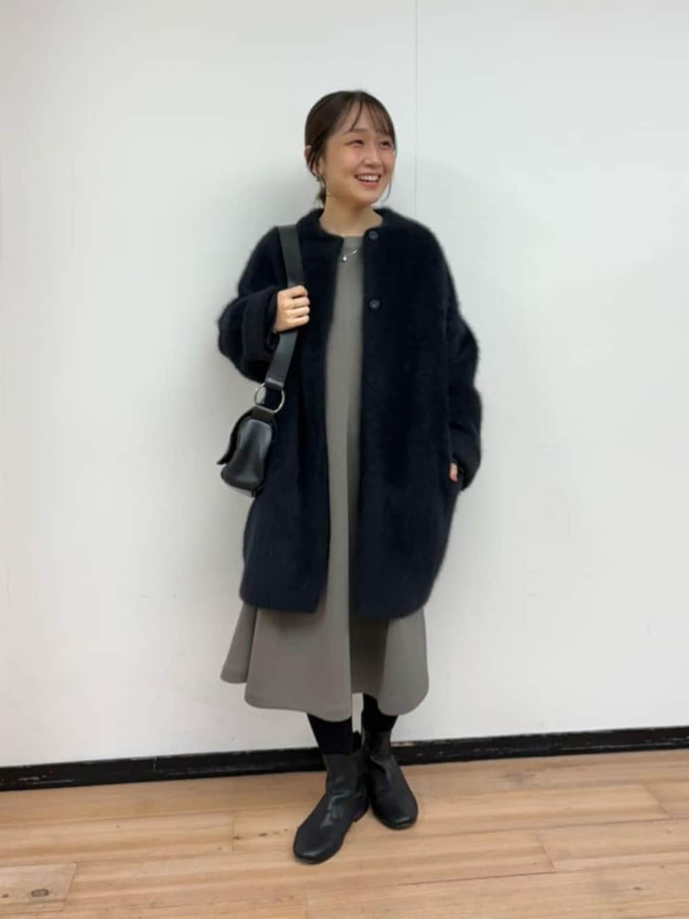 ブラック系のその他アウター、ブラウン系のワンピース、ブラック系のショルダーバッグを着用したレディースの冬コーディネートの2枚目の写真