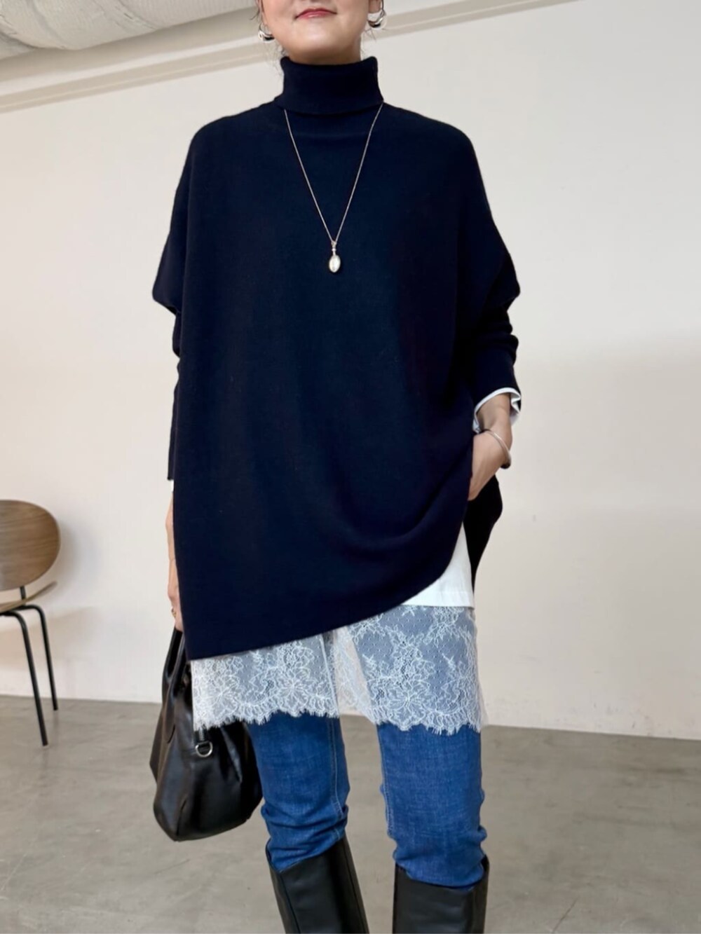 ブルー系のデニムパンツ、ブラック系のトートバッグ、ホワイト系のTシャツ/カットソーを着用したレディースの秋コーディネートの2枚目の写真