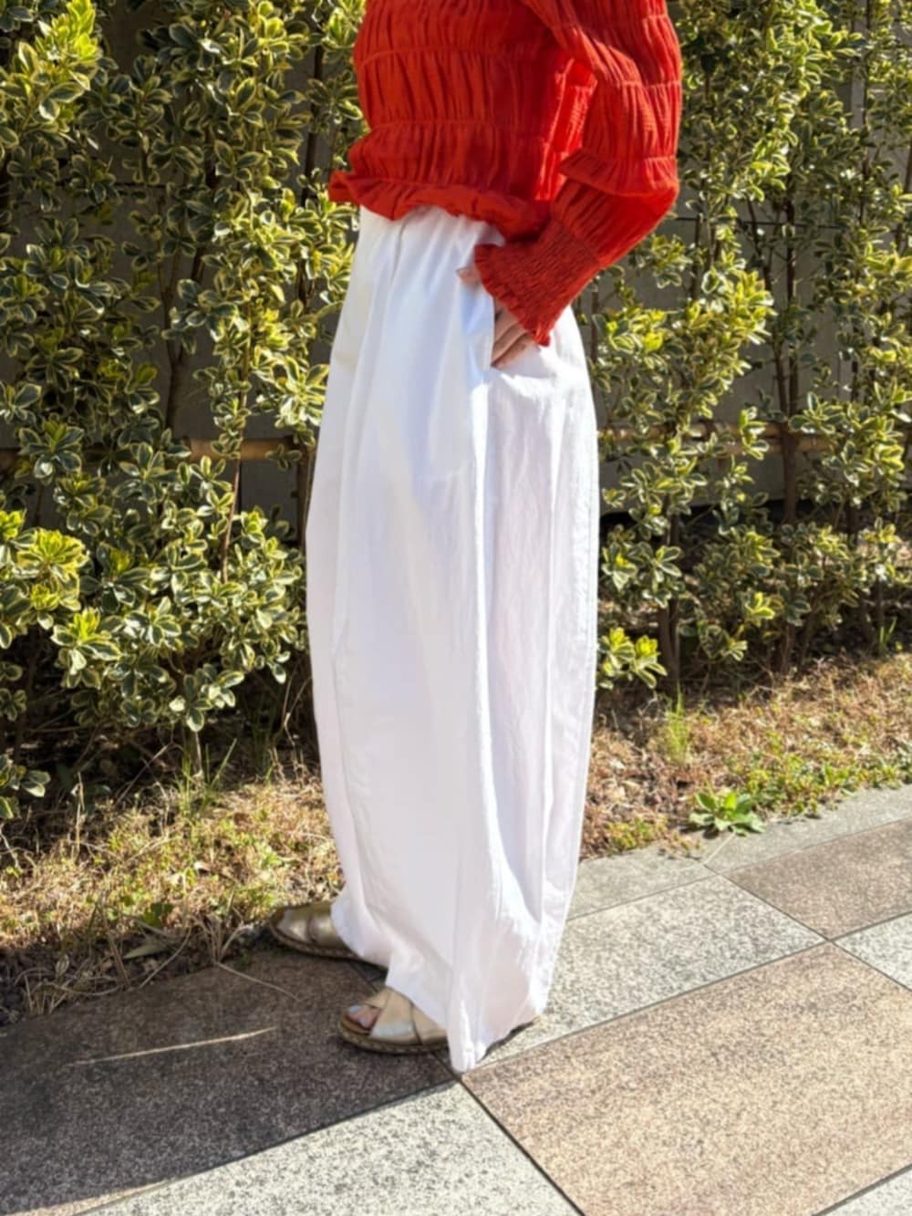 オレンジ系のシャツ/ブラウス、ホワイト系のその他パンツを着用したレディースの春コーディネートの9枚目の写真