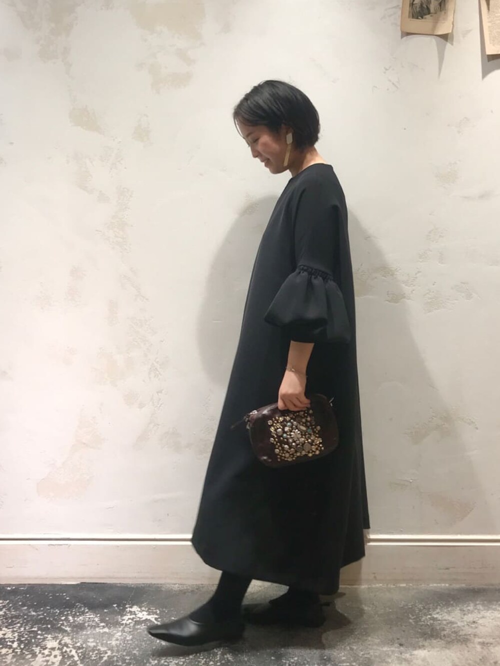 ブラック系のワンピース、ブラック系のトートバッグを着用したレディースの春コーディネートの2枚目の写真