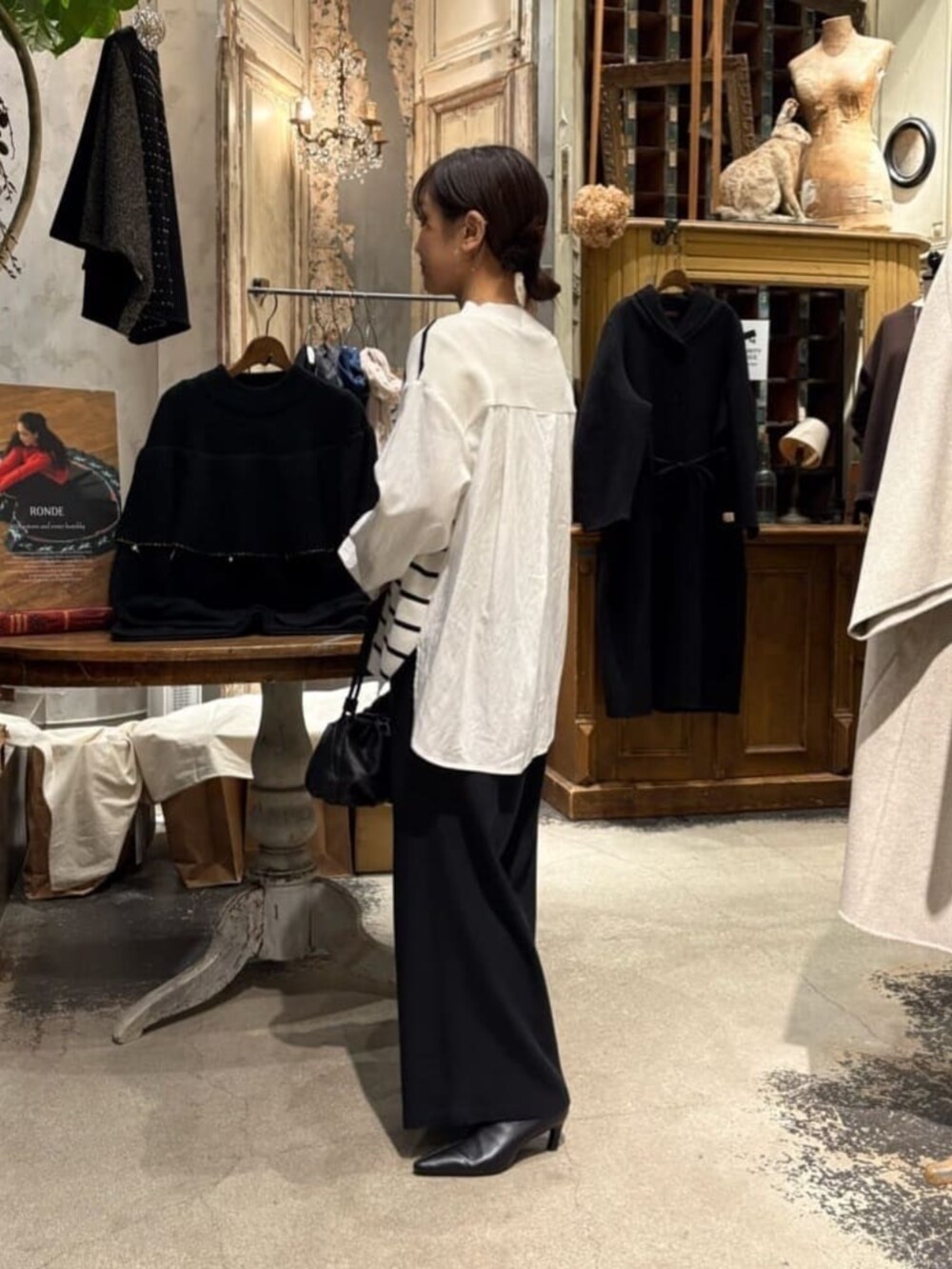 ブラック系のその他パンツ、ホワイト系のニット/セーターを着用したレディースの冬コーディネートの4枚目の写真