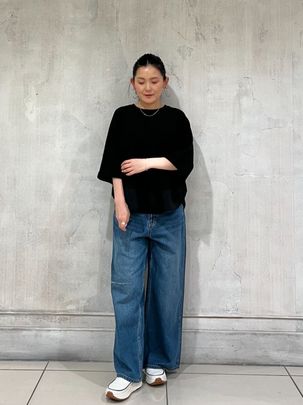ブルー系のその他パンツ、ブラック系のTシャツ/カットソー、ホワイト系のスニーカーを着用したレディースの春コーディネートの9枚目の写真