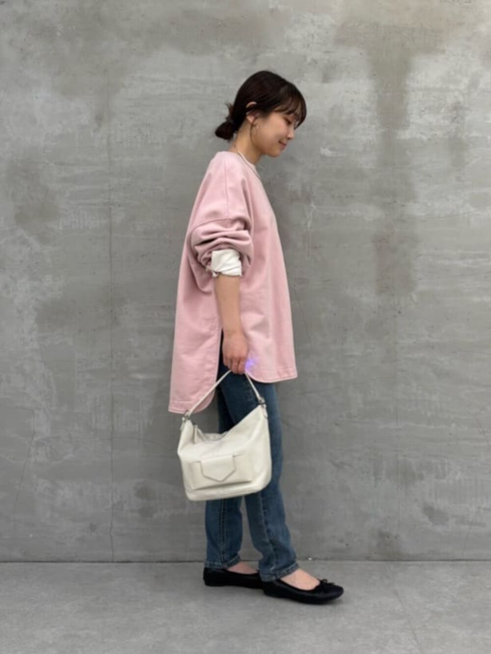 ブルー系のデニムパンツ、ホワイト系のトートバッグ、ピンク系のTシャツ/カットソーを着用したレディースの冬コーディネートの4枚目の写真